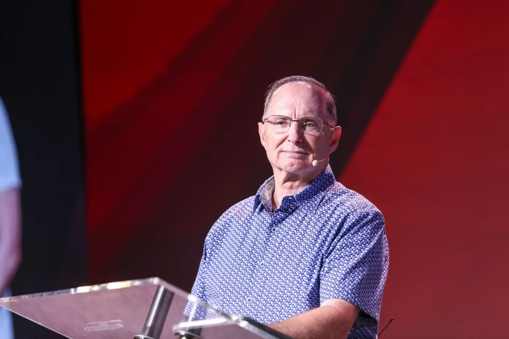 Marvin Yoder preaching in Brazil Red background